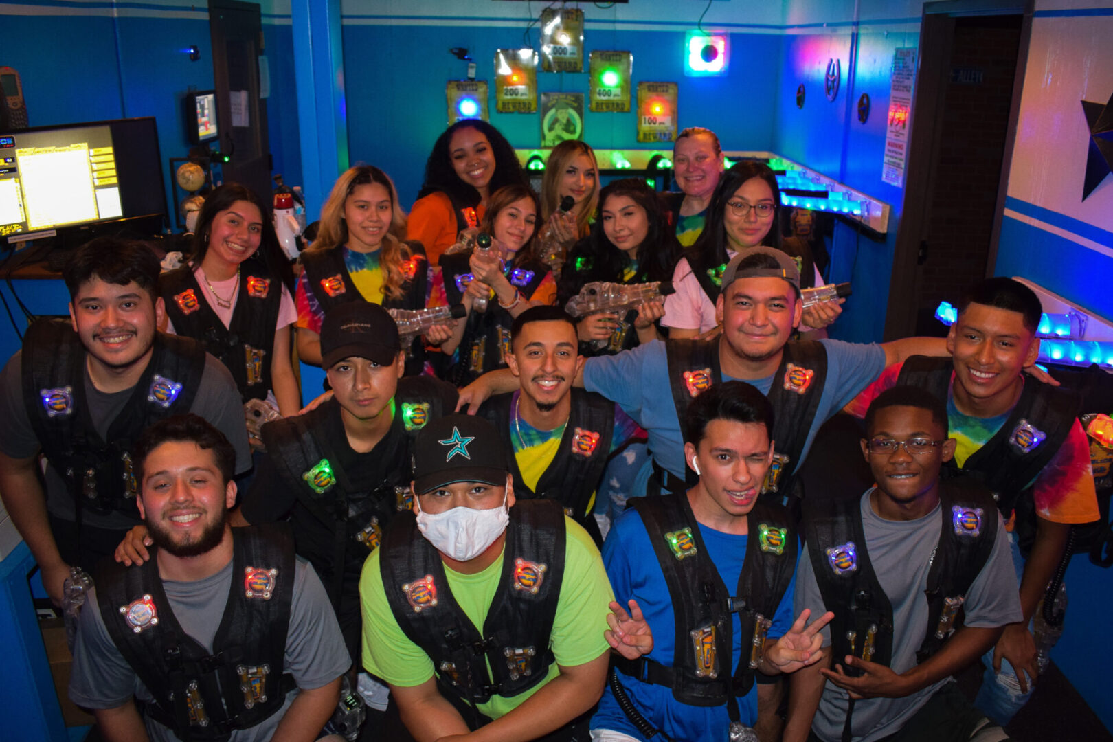 A group of people wearing vests and smiling for the camera.