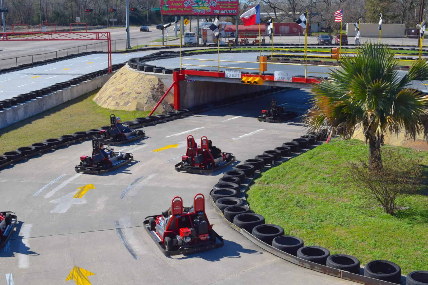 A group of people riding go carts on a track.